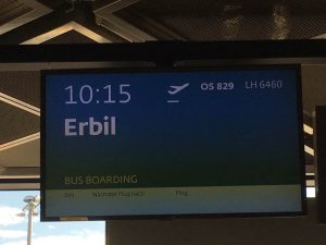 [Image description: photograph of the information board at the airport, showing 10:15 flight to Erbil.]